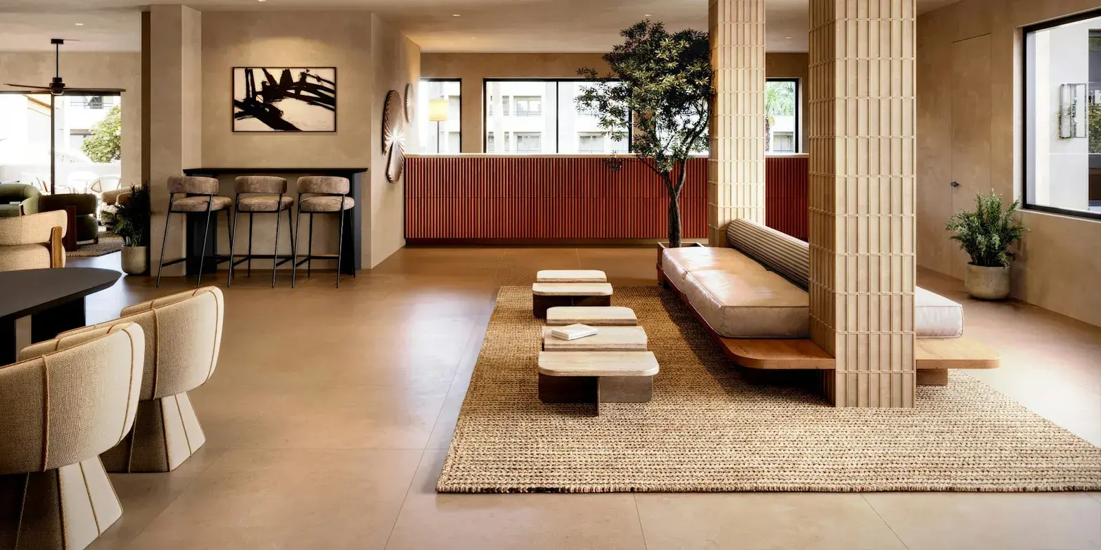 A hotel lobby lounge with low seating on a large natural-fibre rug
