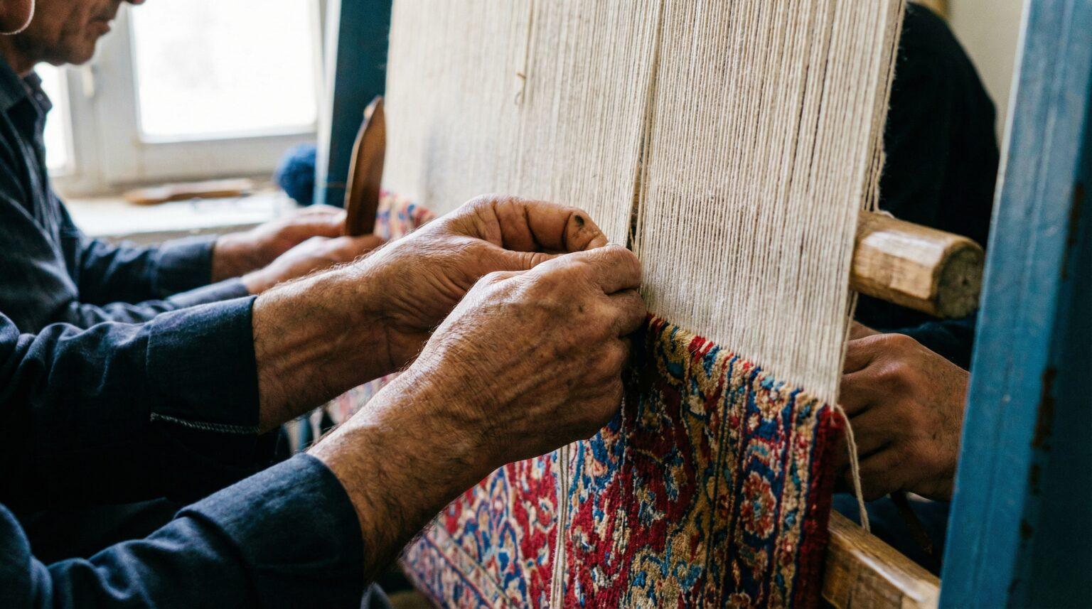Artisan hand-knotting on the loom