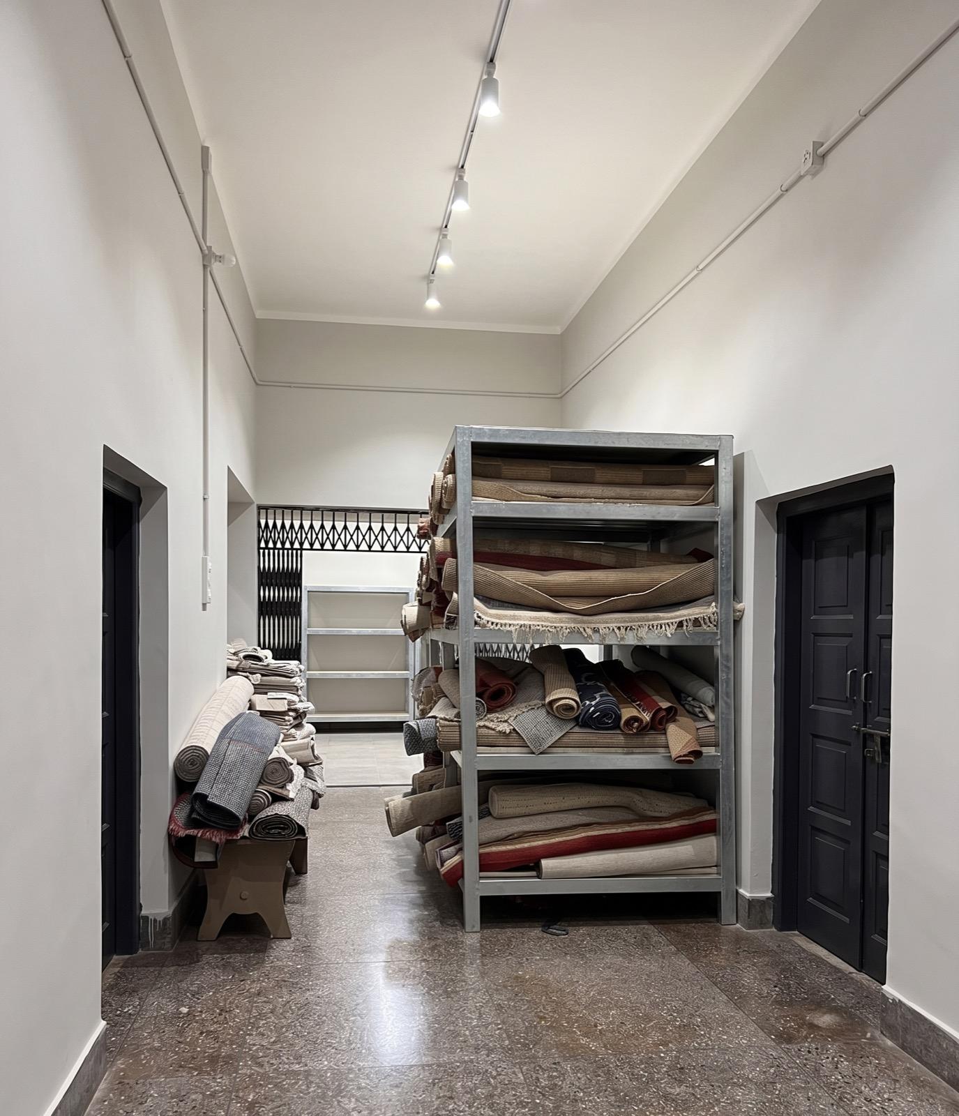Rolled rugs on storage racks awaiting dispatch, Raheem and Son