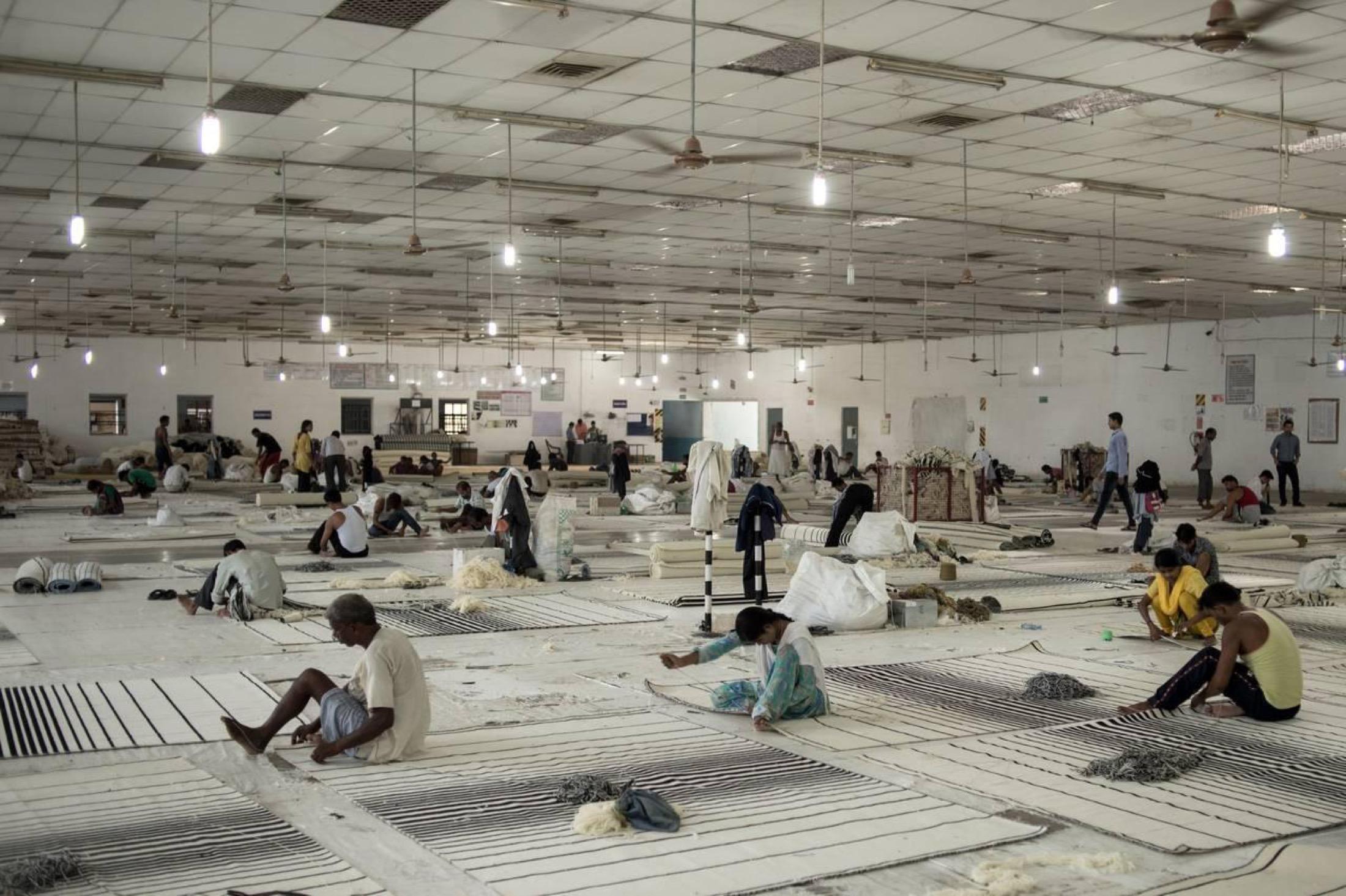 Weavers at work across the finishing hall at Raheem and Son, Bhadohi, Uttar Pradesh, India