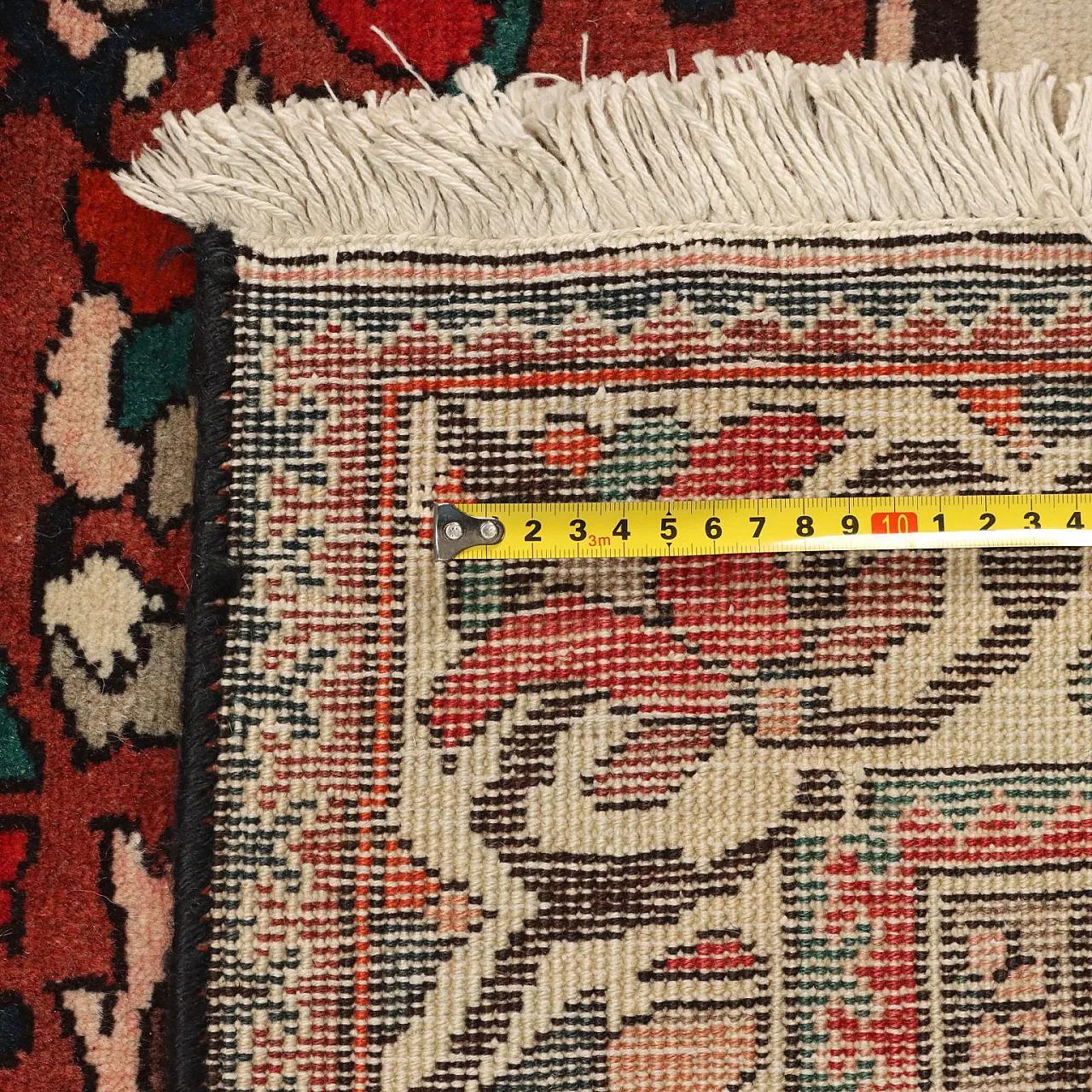 A handmade rug being measured against its specification during inspection