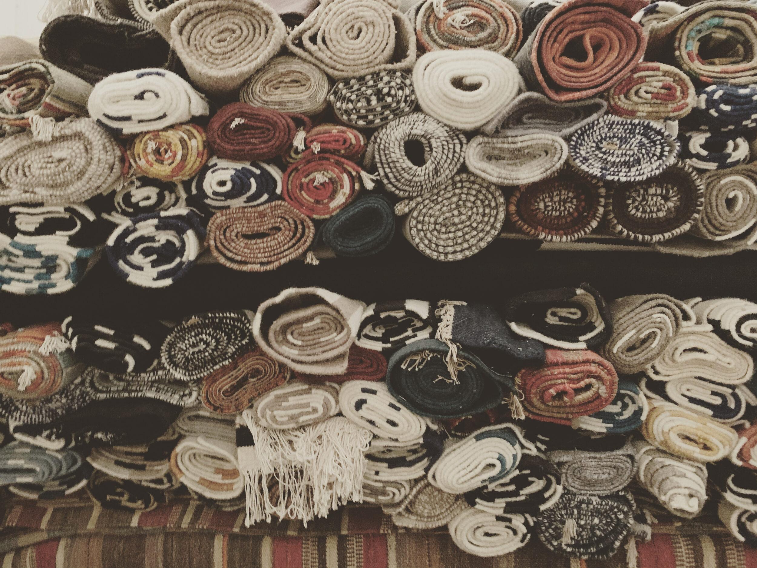 Rolled handmade rugs stacked for dispatch in a Bhadohi warehouse