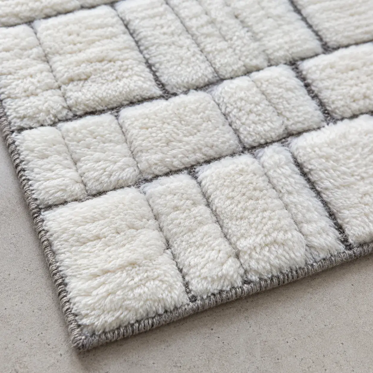 Close view of the Anselm Rug in white grey showing its texture and detail