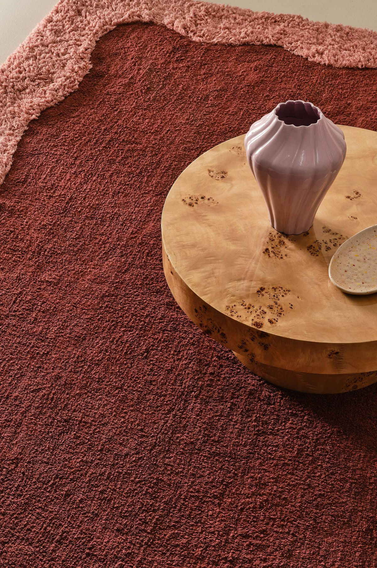A wooden coffee table on a red rug